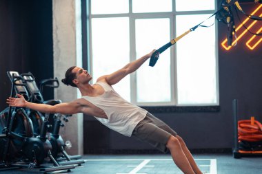 Trx çizgili bakarak yakışıklı iyi inşa adam