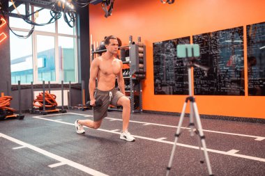 Güzel iyi yapılmış adam dumbells ile egzersiz gösteren