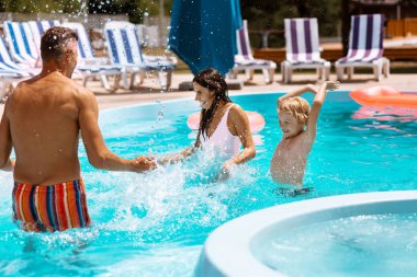 Oğlu ve anne havuzda eğlenirken su sıçrayan