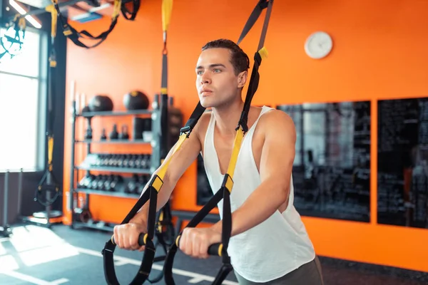 Pleasant well built man doing a resistance exercise