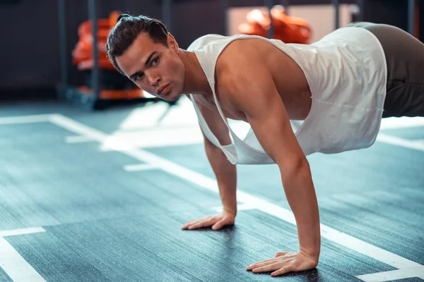 Ciddi iyi inşa edilmiş adam yere ellerini koyarak