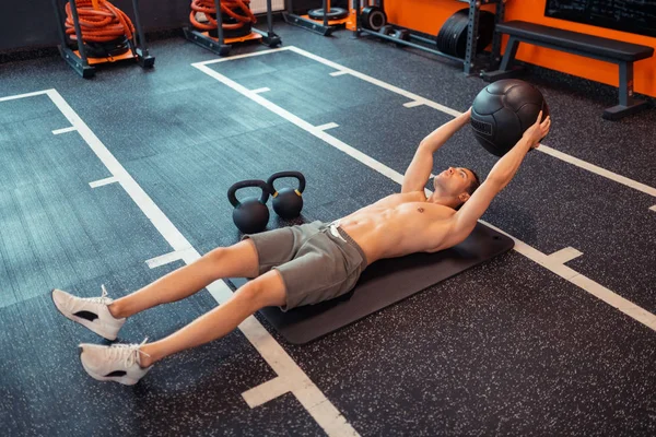 Özel bir top tutan iyi görünümlü atletik adam