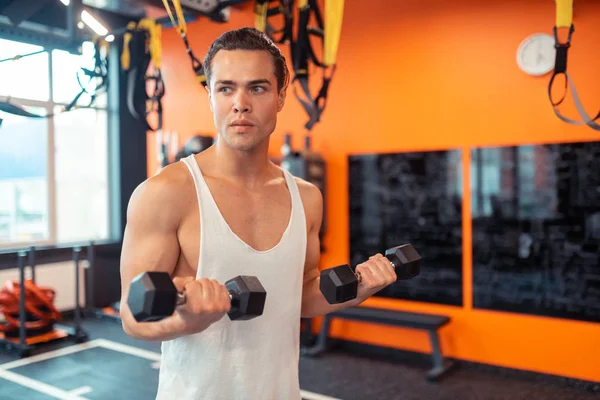 Sérieux homme attrayant travaillant sur ses muscles — Photo