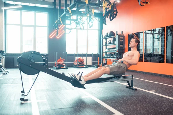 Schöner fitter Mann, der allein im Fitnessstudio trainiert — Stockfoto