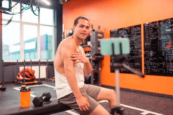 Attractive young man speaking about his biceps