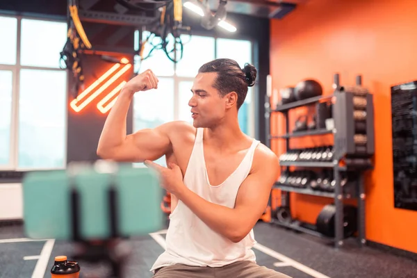 Neşeli güzel adam onun kasları bakıyor