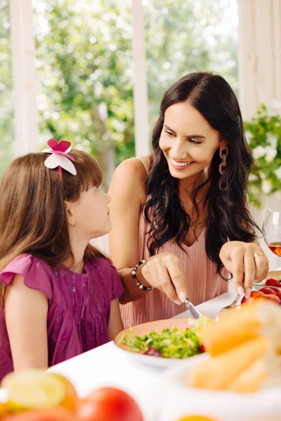 Madre sorridente mentre dà insalata per sua figlia — Foto Stock