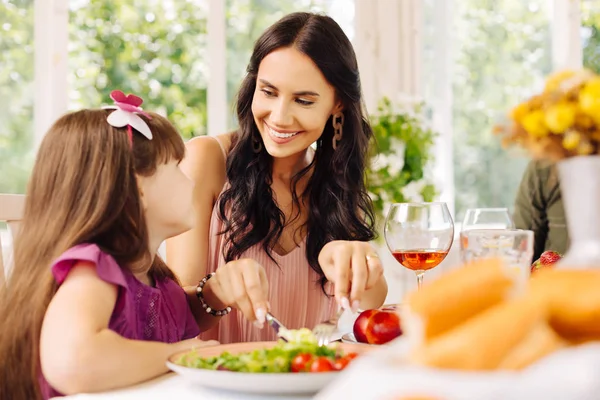 Donkerharige Mama die voor haar meisje zorgt terwijl ze lunchen — Stockfoto