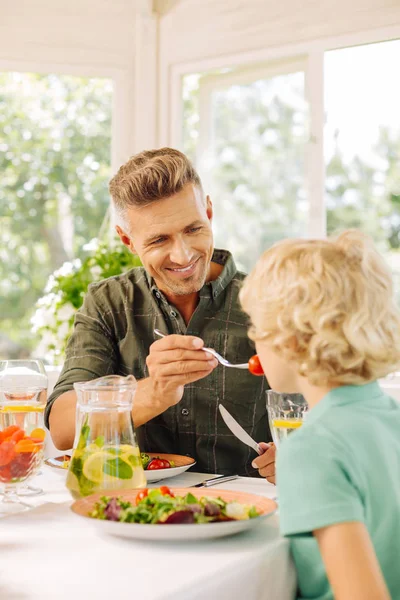 Knappe man geeft wat tomaat voor zijn zoon — Stockfoto