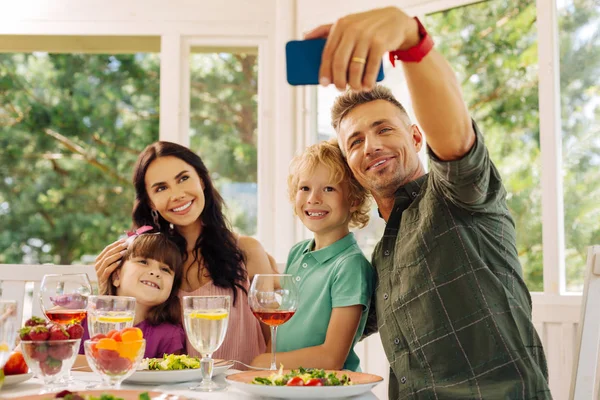 Man neemt zijn smartphone terwijl het maken van selfie met familie — Stockfoto