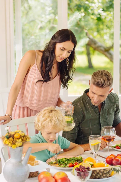 Cura mamma guardando il figlio mangiare in casa estiva — Foto Stock