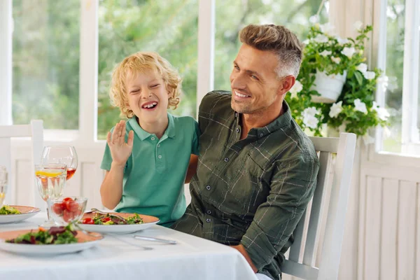 Filho e papai rindo enquanto almoçam juntos — Fotografia de Stock