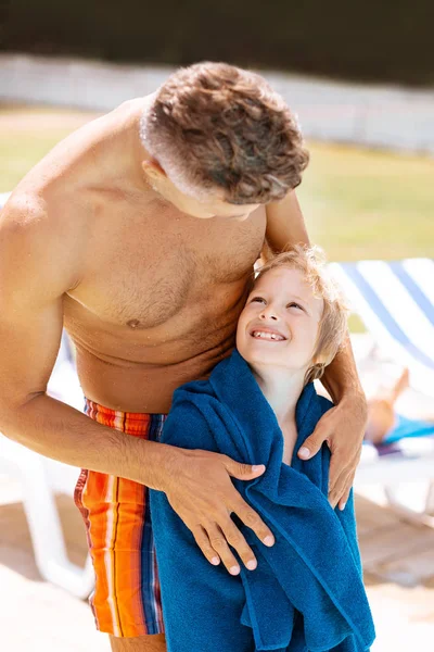 Papá mirando a su hijo sonriente de pie en toalla — Foto de Stock