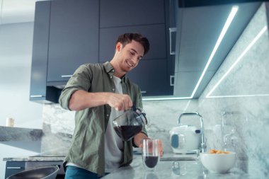 Yakışıklı adam sabah fincan içine kahve döküyor
