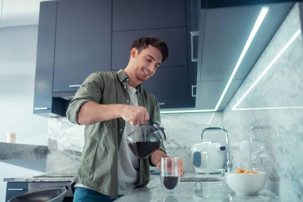 Stilig man hälla kaffe i koppen på morgonen — Stockfoto