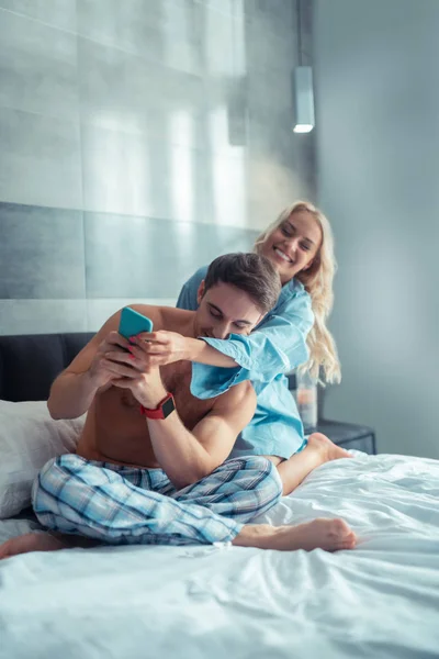 Namorada ciumenta sorrindo enquanto toma o telefone de seu namorado — Fotografia de Stock