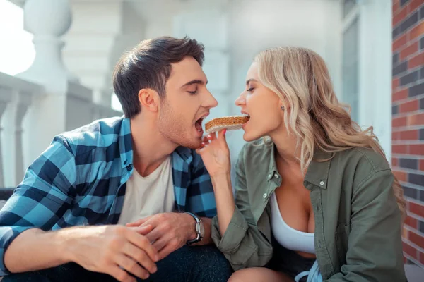 Couple eating wafer together while enjoying breakfast outside — Stock Photo, Image