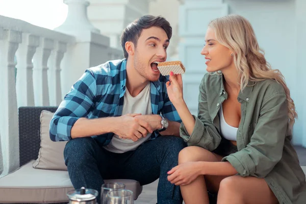 Caring wife giving wafers to her handsome man — Stock Photo, Image