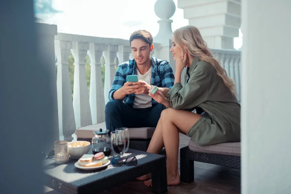 Vriendin eten cookie en luisteren naar haar man — Stockfoto