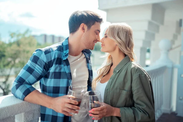 Couple kissing while drinking coffee standing on balcony — Stock Photo, Image