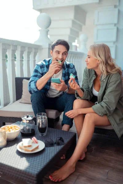 Good-looking couple sitting on balcony and having breakfast — Stock Photo, Image