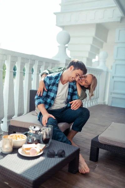 Wife hugging man while having breakfast on balcony — Stock Photo, Image