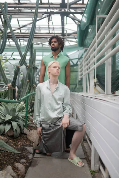 Modely s extravagantními oděvy pózujících ve skleníku — Stock fotografie