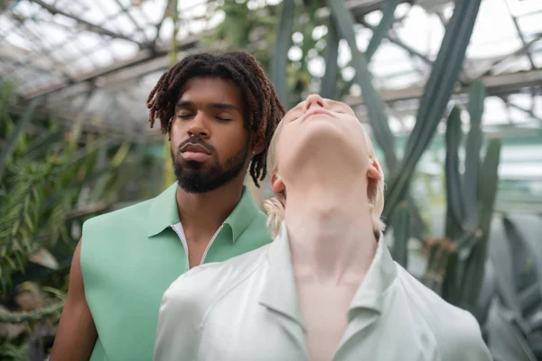 Bearded model closing eyes while posing with colleague