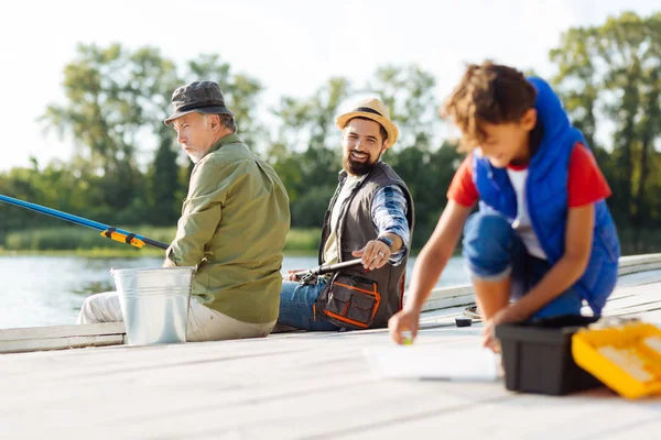 Bearded father asking his son to find fishing hook — Stock Photo, Image