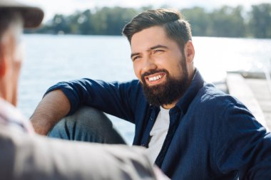 Babasını dinleyen yakışıklı koyu saçlı adam