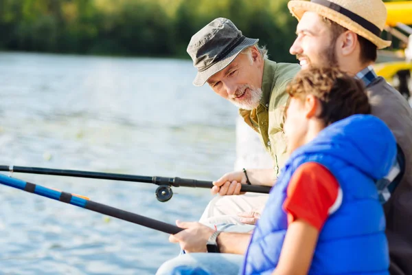 Avô falando com o neto enquanto tem pesca familiar — Fotografia de Stock