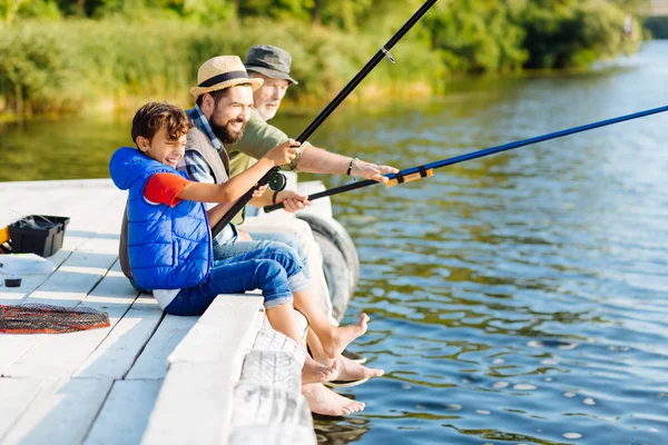 Hombres de tres generaciones sintiéndose felices mientras pescan en verano — Foto de Stock