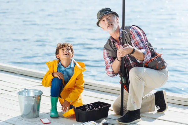 Avô e menino olhando para a pesca enfrentar — Fotografia de Stock