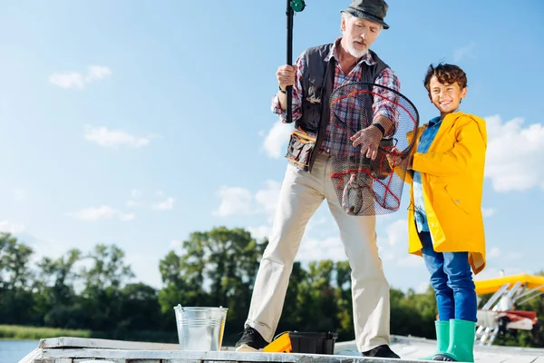 Man stående nära barnbarn känner sig lycklig efter att fånga fisk — Stockfoto