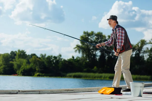 Sakallı gri saçlı adam balık tutarken kendini iyi hissediyor — Stok fotoğraf