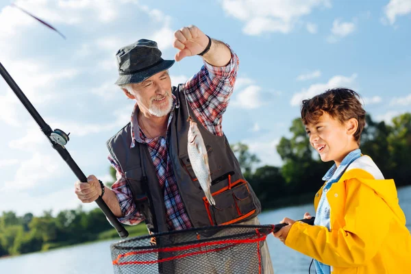 Vacker ung upphetsad pojke fiske med farfar — Stockfoto