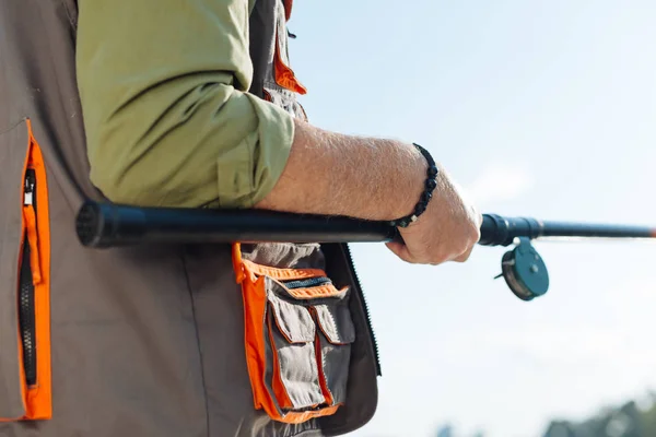 Närbild av mannen bär svart armband fånga fisk — Stockfoto