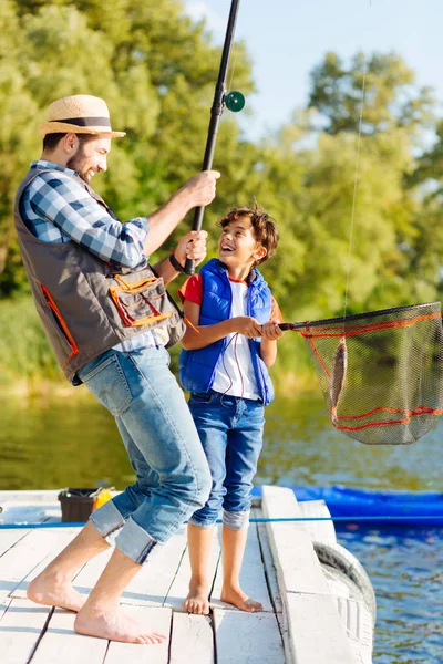 Fils se sentir excité après avoir attrapé le poisson avec papa — Photo