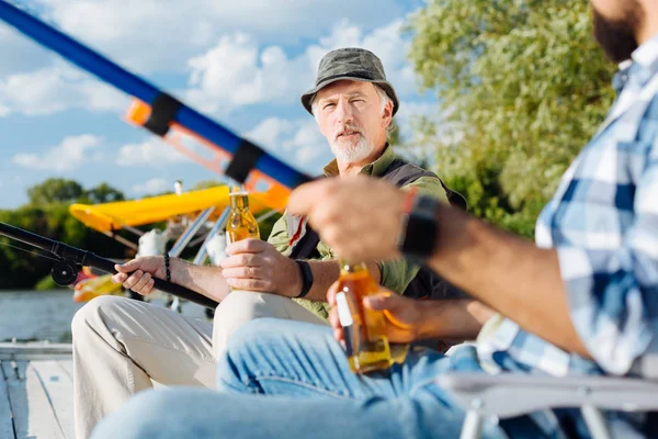 Father and son drinking beer and catching fish — Stock Photo, Image