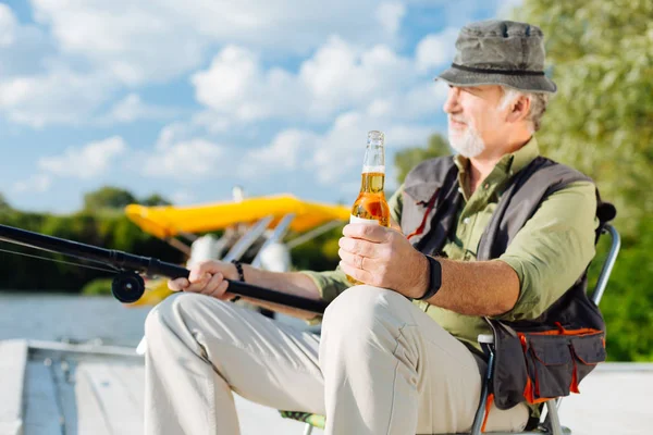 Homem se sentindo relaxado enquanto bebe cerveja e pesca — Fotografia de Stock