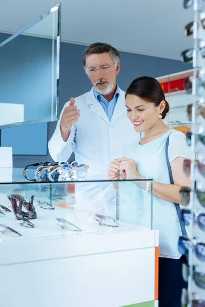 Pleasant pretty woman looking at different sunglasses — Stock Photo, Image