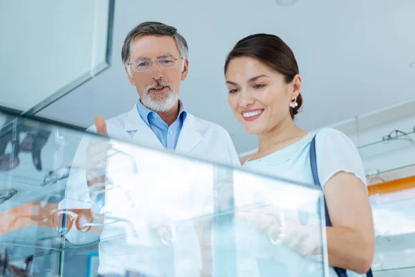 Médico amigable positivo que le dice al visitante sobre las gafas — Foto de Stock