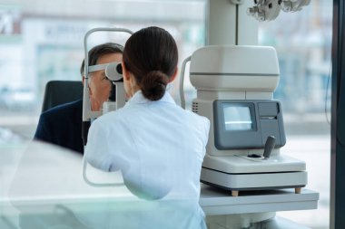 Optik alet kullanarak güzel koyu saçlı kadın