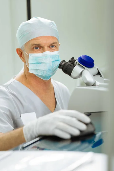 Ernstige professionele oogarts die zijn patiënt visie controleert — Stockfoto