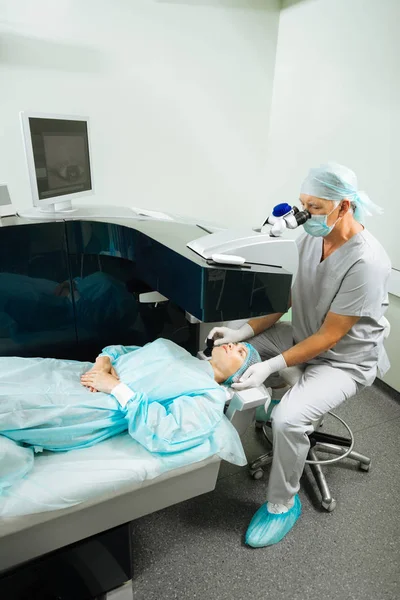 Профессиональный серьезный врач проверяет зрение своих пациентов — стоковое фото