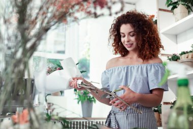 Kalın dallar için secateurs kullanarak özenli genç kırmızı saçlı çiçekçi