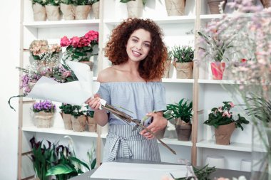 Atölyesinde kalan hafif kıyafetli gülümseyen kıvırcık kadın