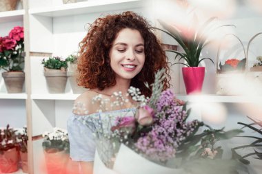 Gülen pozitif kızıl saçlı kadın güzel renkli buket arıyor