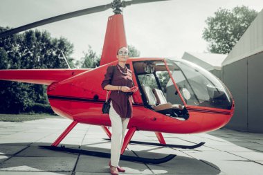 Müreffeh sevimli iş kadını özel helikopter yakınında ayakta