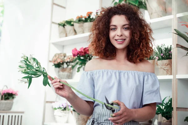Pealing redhead curly girl working in flower shop — Stock Photo, Image